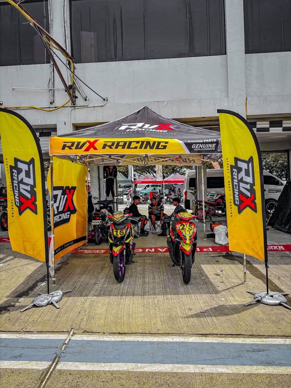 The RVX Racing awning in the pit lane with two race bikes parked under it