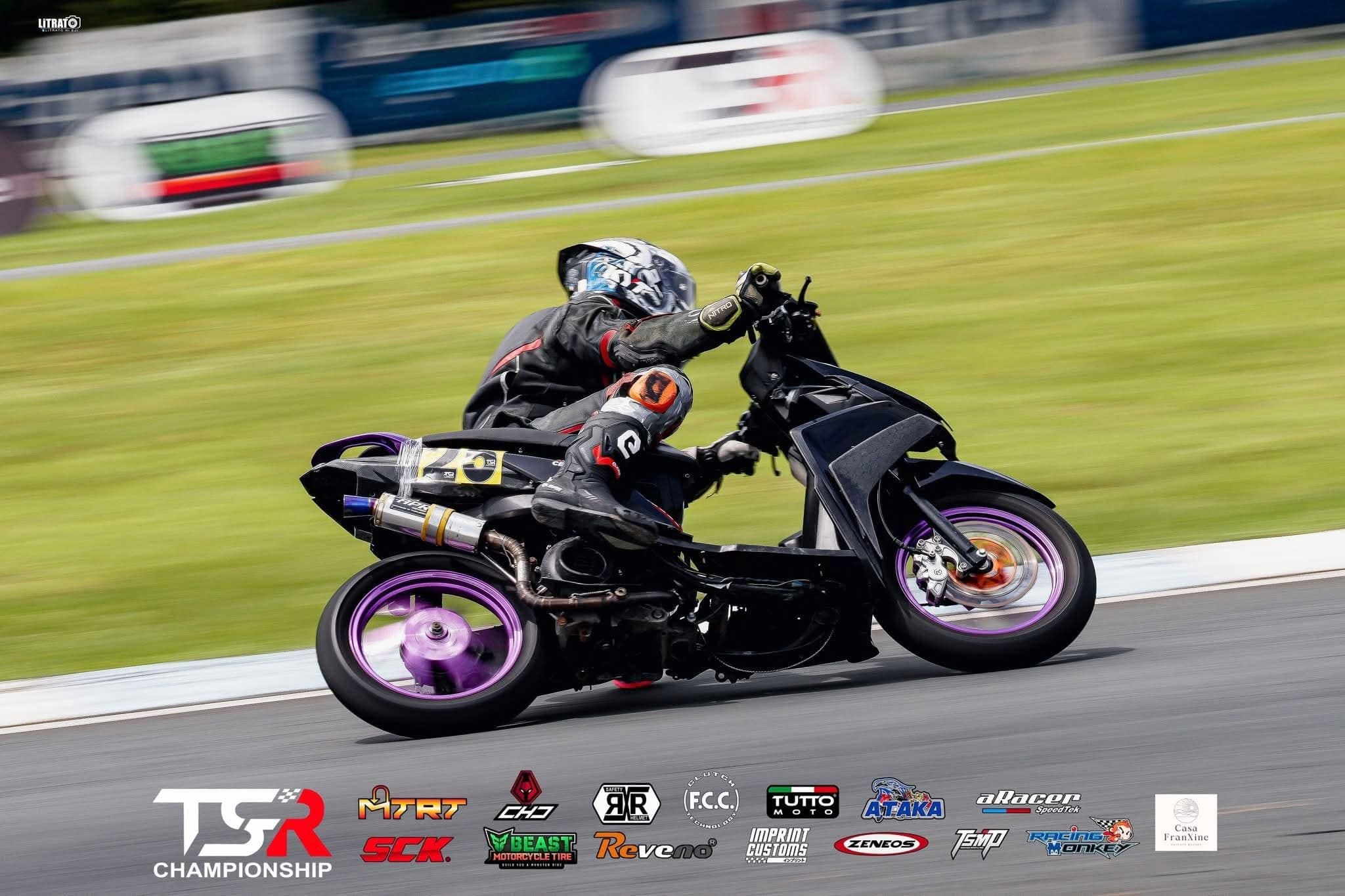 A race scooter at speed on the straight, the background panned to a blur