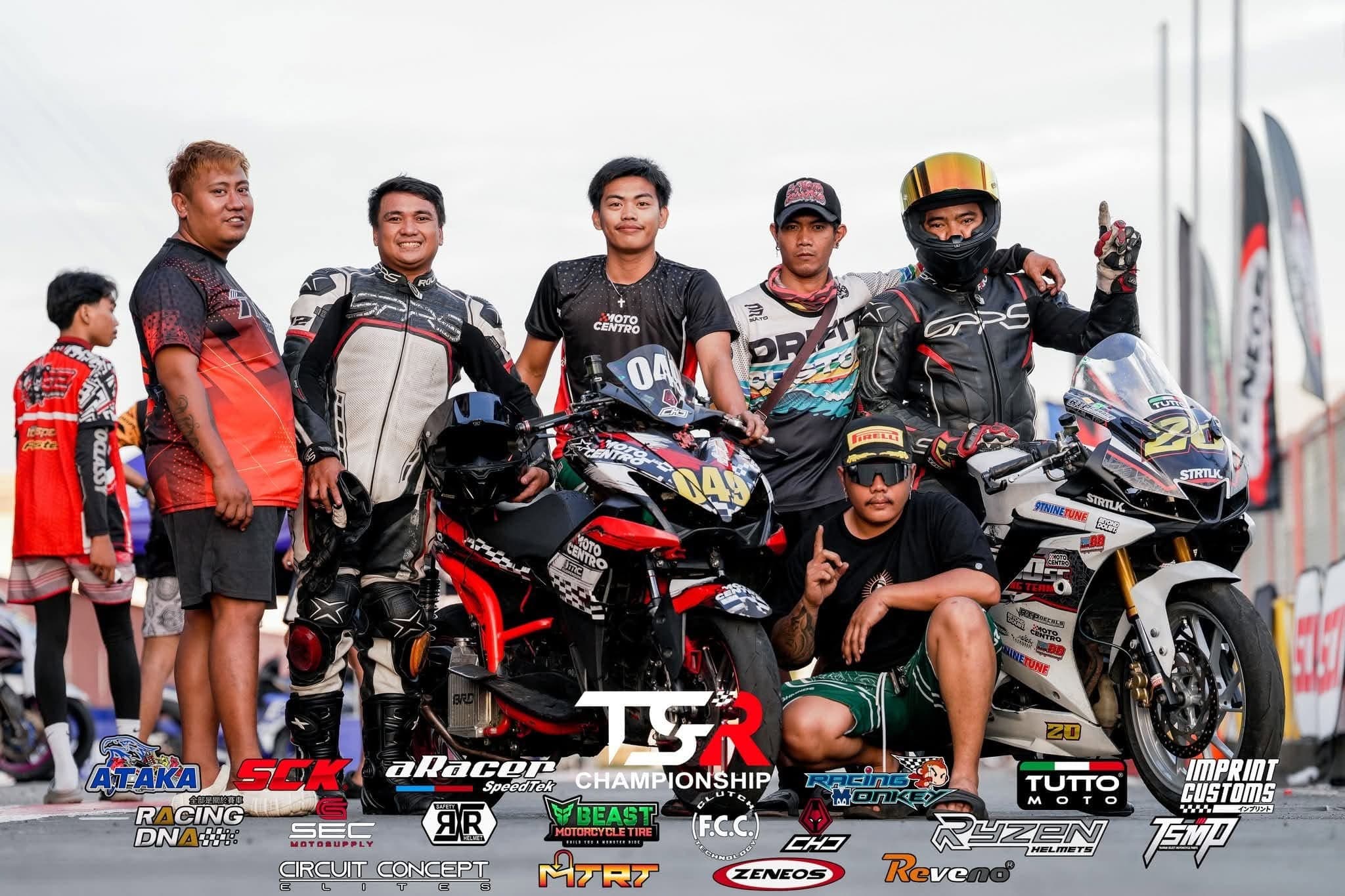 The team standing beside two race bikes at the end of the day